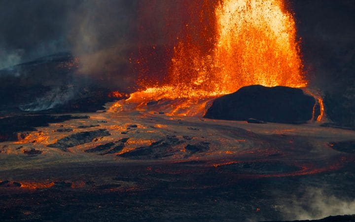 A lava fountain rising from Kīlauea’s summit crater at dusk