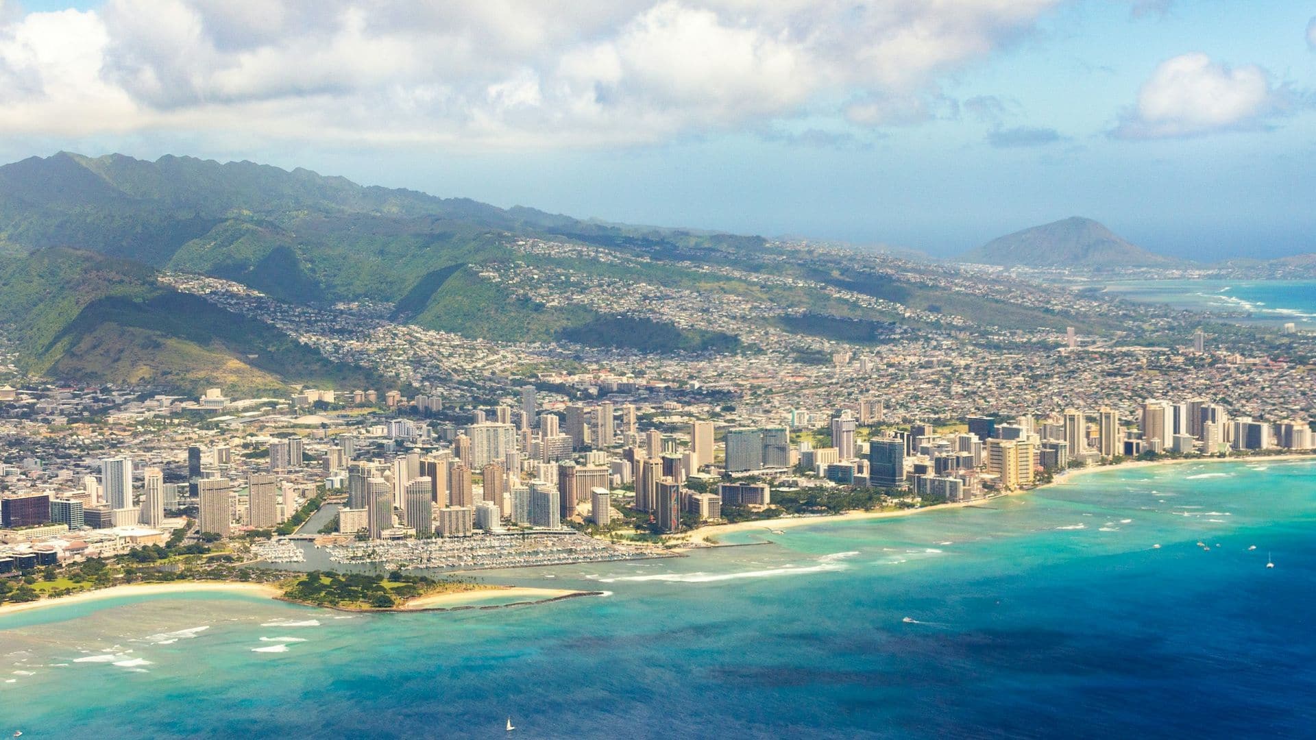 Aerial view of Honolulu’s high-rises along a turquoise shoreline