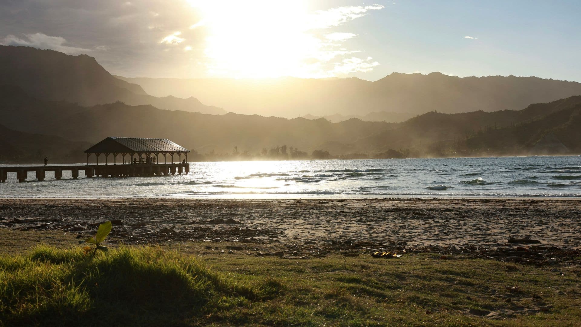 The Hanalei pier silhouetted against the sunset and misty mountains