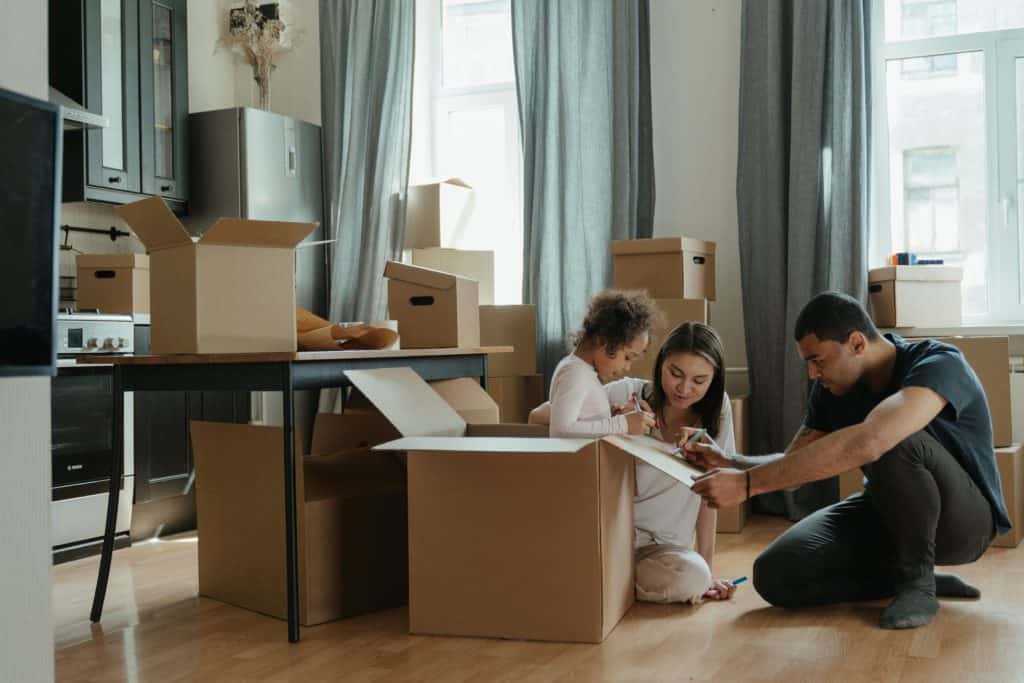 People in living room packing boxes